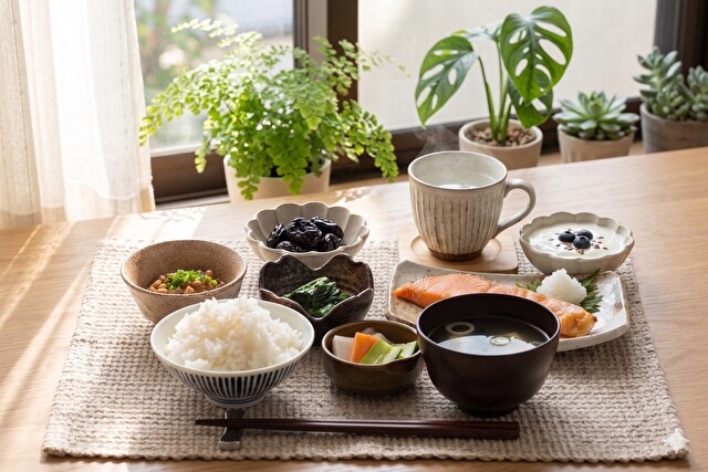 光が差し込むテーブルに、白湯やプルーンなどが並ぶ健康的な朝食風景「※写真はイメージです」