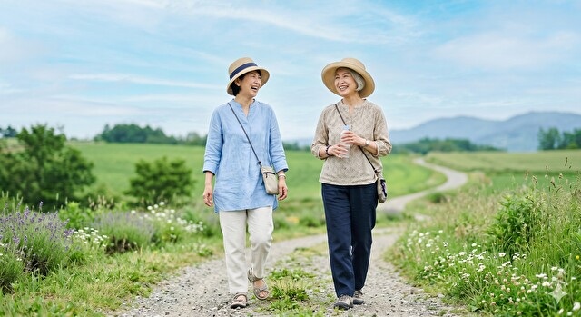 青空の下、笑顔でハツラツと歩く50代・60代の女性の写真「※写真はイメージです」